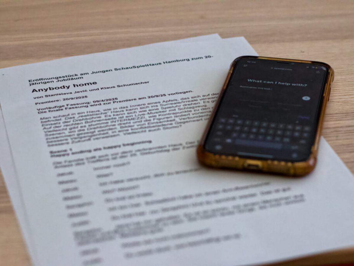 Das Bild zeigt einen Stücktext. Dadrauf liegt ein Handy