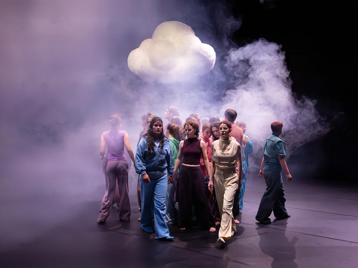 Ein großer Teil des Ensembles steht nah beieinander im Nebel. Sie bewegen sich auseinander. Über ihnen ist eine Wolke. 