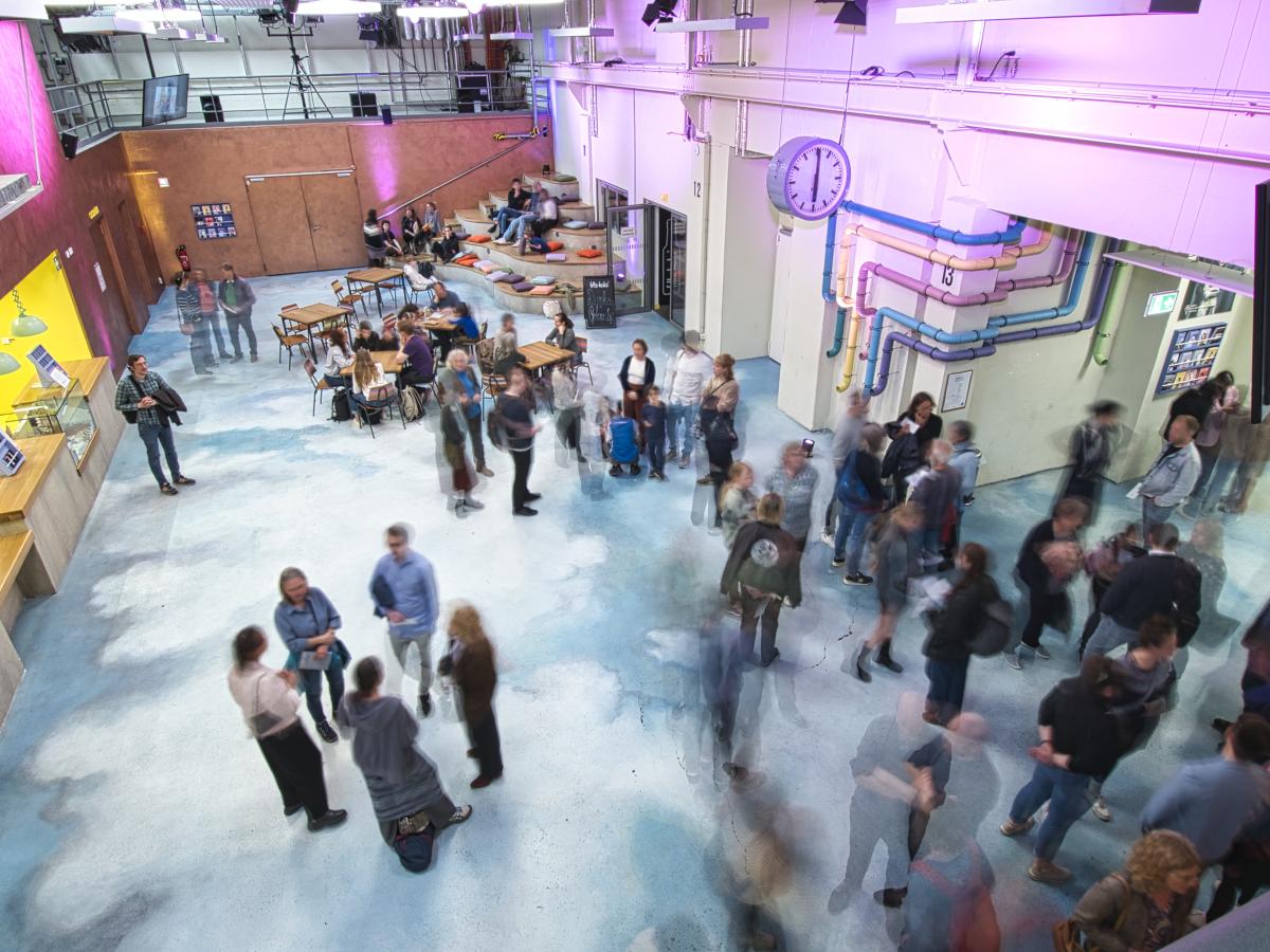 Das Foto zeigt das Foyer des JSH mit Publikum